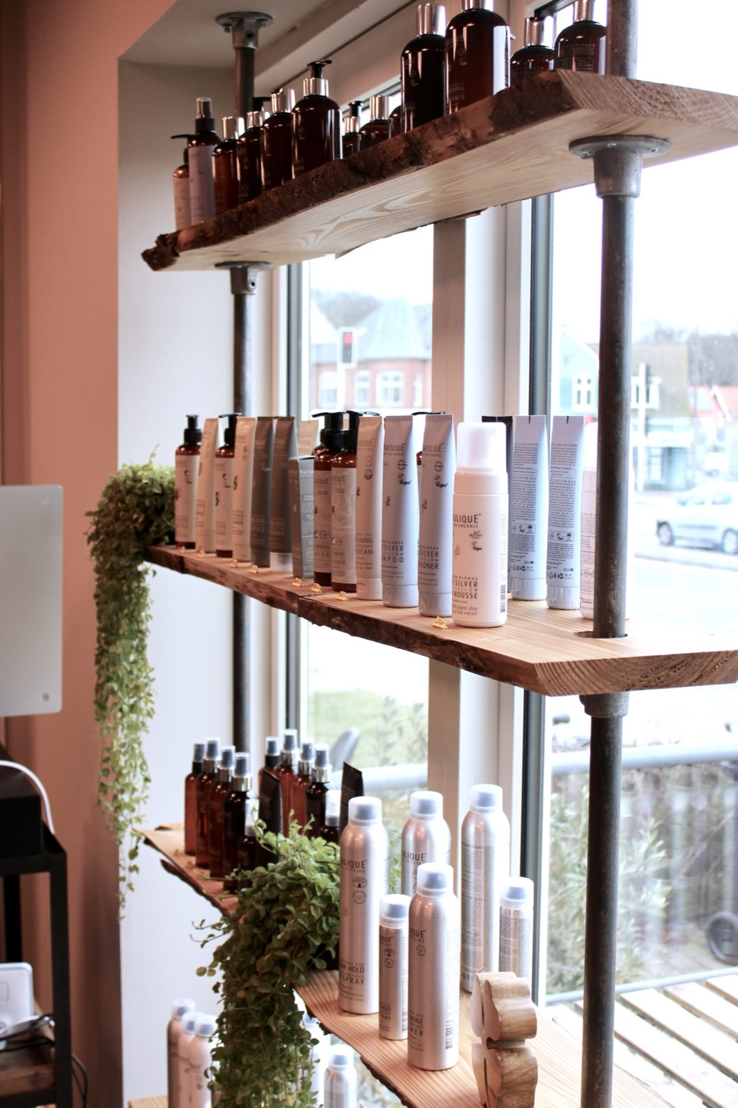 Lyse, rolige omgivelser i Nordic Hairlounge med økologiske hårprodukter på træhylder